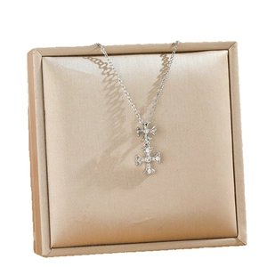 Elegant double cross pendant necklace in silver with sparkling crystals on jewelry display