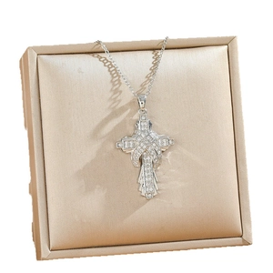 Exquisite silberne Kreuzkette mit Pavé-Mikro-Diamanten auf einer Schmuckschatulle