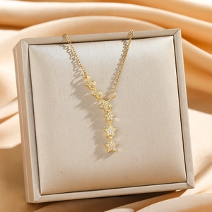 Elegant gold star tassel necklace with shimmering cubic zirconia in luxury jewelry box