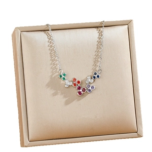 Colorful zircon flower pendant necklace in titanium steel on a champagne jewelry pad