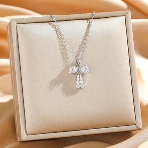 Elegant bow pendant necklace with heart-shaped crystals and tassels on jewelry box