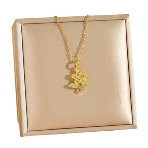 Exquisite gold floral titanium necklace with sparkling crystals on champagne display board