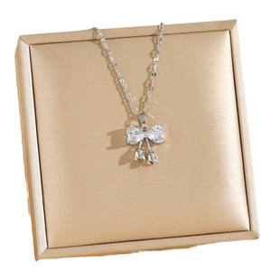 Titanium steel bowknot necklace with zircon pear-shaped crystals on gold jewelry box