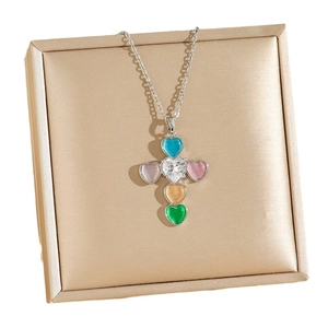 Silver necklace with a colorful heart-shaped zircon cross pendant on a jewelry box