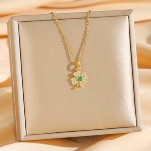 Élégant collier trèfle à quatre feuilles doré avec pierre verte sur soie champagne