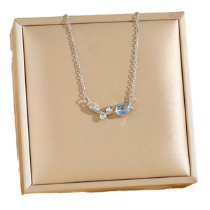 Collier tulipe élégant avec pierre bleue et zircons sur fond de satin couleur champagne