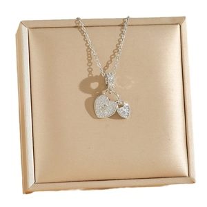 Collier cadenas cœur en argent avec zircons posé sur un écrin de bijoux doré chic