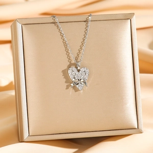 Collier pendentif cœur en acier titane avec nœud et zircon sur satin doré