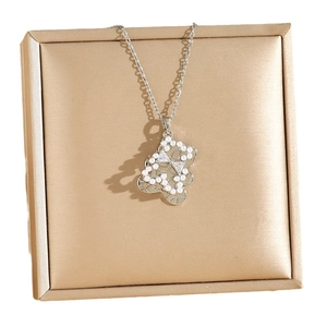 Bear pendant necklace with pearls and crystals on a golden jewelry display mat