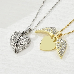 Vue macro du pendentif coeur ouvrant avec ailes et pierres de zircone scintillantes