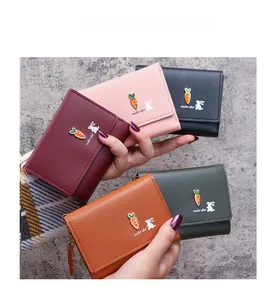 Close-up of five colorful mini leather wallets with bunny prints and carrot ornaments