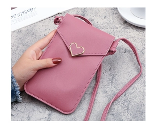 Dettaglio borsa porta cellulare rosa con fibbia a cuore e texture in pelle martellata