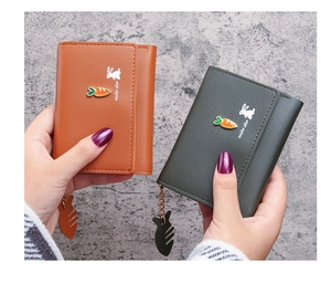 Close-up of compact leather wallets with rabbit silhouette and carrot detail