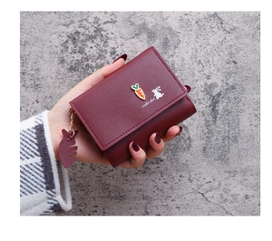 Detail of burgundy PU leather wallet featuring rabbit silhouette and carrot pendant