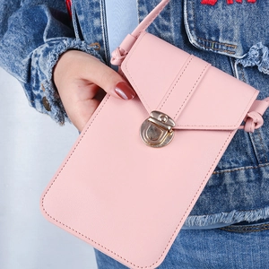 Pink PU leather crossbody phone bag with vintage metal clasp worn on denim jacket