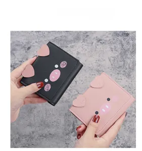 Short tri-fold wallets in pink and black featuring cute cartoon pig faces and heart ears