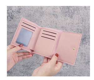 Pink tri-fold faux leather wallet featuring multiple card slots and a metal snap closure