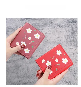 Détail de portefeuilles rouges et roses avec imprimés floraux blancs et texte LOVE