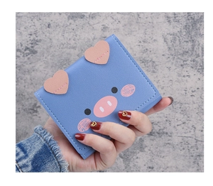 Close-up of blue leather wallet featuring cute cartoon pig details and white stitching