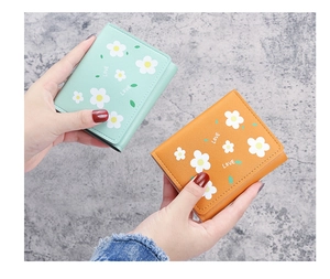 Détail de portefeuilles trifold en menthe et jaune avec marguerites et motif LOVE