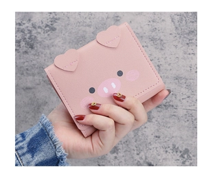 Detail of cute pink cartoon pig wallet with heart-shaped ears and textured PU leather