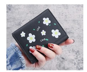 Détail d'un petit portefeuille noir à trois volets avec imprimé marguerite et LOVE