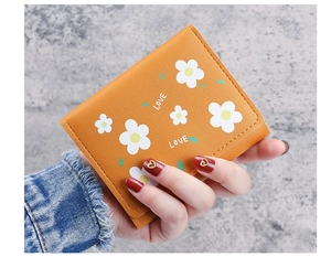 Vue détaillée du portefeuille en cuir PU orange avec imprimés marguerites et mot LOVE
