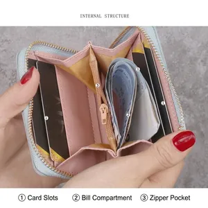 Short blue leather wallet for women with card slots and pink lining interior view