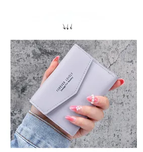 Detail der lavendelvioletten kurzen Brieftasche mit Forever Lovely Text in der Hand