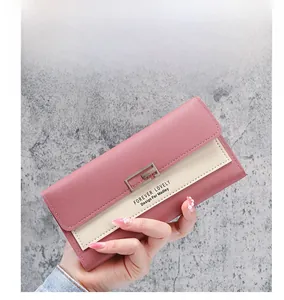 Detail of pink and beige tri-fold PU leather wallet with metallic buckle and branding