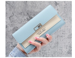 Detail of light blue and beige trifold faux leather long wallet with metal clasp closure