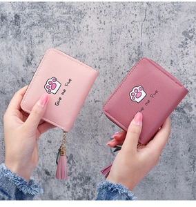 Detail of compact zip wallets with cute cat paw prints and elegant tassel zipper pullers