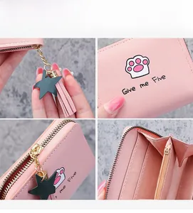 Close-up of pink PU leather wallet showing cartoon print, star tassel, and card slots