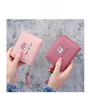 Detail of pink and rose red PU leather wallets featuring cute cat paw prints and tassels