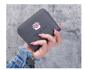 Detail of grey zip wallet with cute cat paw print and star charm in hand