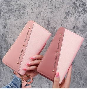Detail of pink patchwork wallets with heart charms and metallic zipper closure