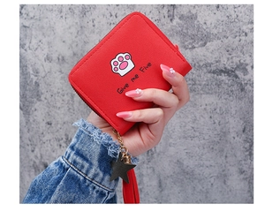 Detail of red zipper wallet featuring a pink cat paw print and leather tassel charm