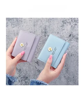 Detail showing lavender and light blue tri-fold wallets with daisy metal snaps