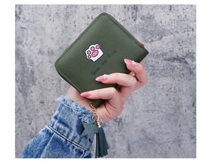 Close-up of dark green matte wallet with pink cat paw print and tassel star charm