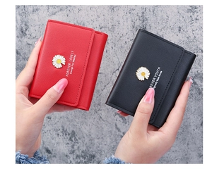 Close-up of red and black leather trifold wallets with daisy metal hardware detail