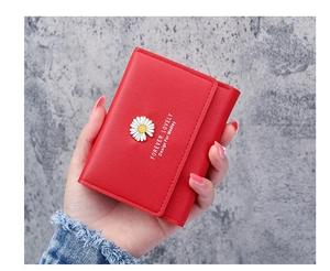 Close-up of red tri-fold wallet for women featuring a white daisy metal ornament decoration