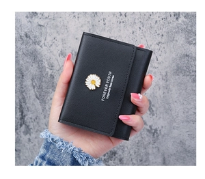 Close-up of black daisy wallet for women showing the floral charm and metal buckle detail