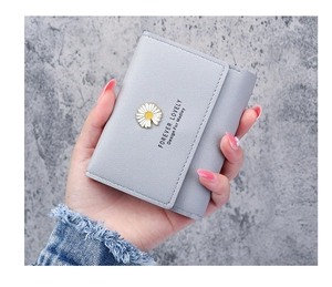 Close-up of small tri-fold wallet with daisy emblem and neat stitching detail