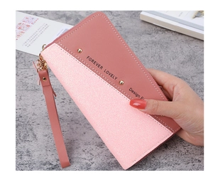 Detailed view of long pink wallet with glitter patchwork and gold stud accents