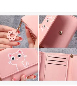 Detail view of pink cat wallet showing golden charm chain and internal card slots