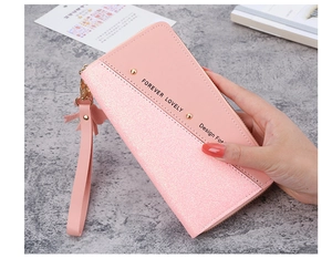 Close-up of pink long wallet with glitter patchwork and golden zipper details