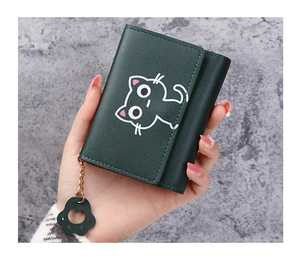 Close-up of a green cat pattern tri-fold purse in hand with cat paw gold pendant