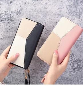 Detail of color-block long wallets with leather texture, tassel zippers, and gold hardware