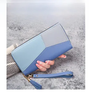 Detail of color-block long wallet with wristlet, tassel, and pebbled leather texture