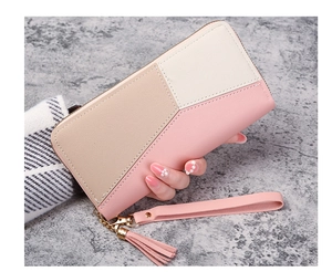 Close-up of color-block long wallet with golden zipper, wrist strap and tassel charm